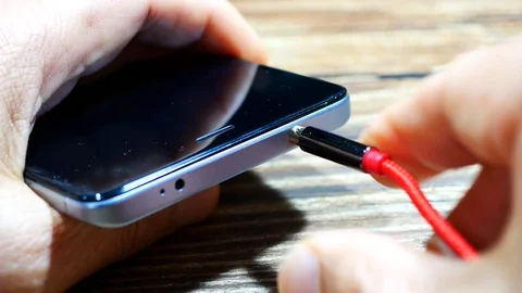 Close up of a man's hand inserting and removing audio or headphone cable with Stock Footage 128829083