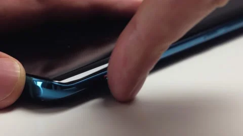 Close-up of a man's hand inserting an empty nano-SIM card tray into a modern Stock Footage 156508841