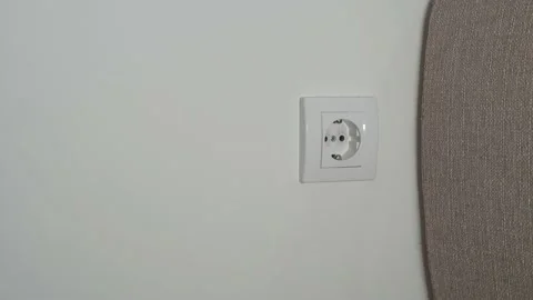 A close-up of a man's hand inserts a black wire to power a white rosette against Stock Footage 202143384