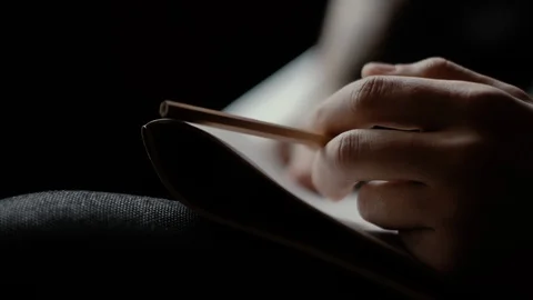 Close-up man's hand knocks nervously on the pad with pencil on dark background Stock Footage 108671810