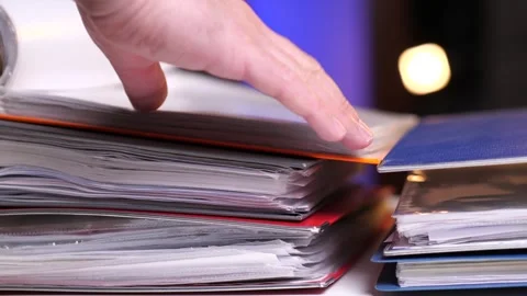 Close-up man's hand leafing through documents in a orange, red, blue folders Video stock 270998831