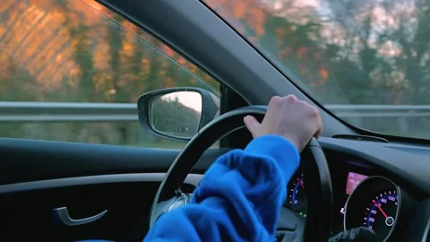 A close-up of a man's hand loosely holding steering wheel of a car Stock Footage 304649762
