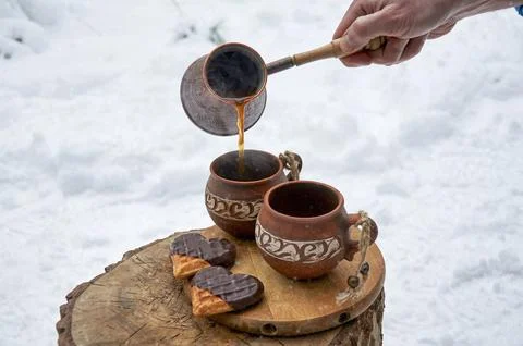 Close up of a man's hand making coffee outside in the forest in winter Stock Photos