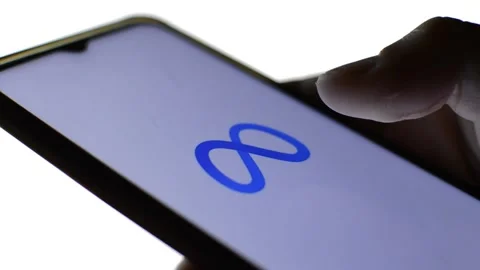 Close-up man's hand with meta icon on his phone. cyberspace metaverse logo Stock Footage 196276361
