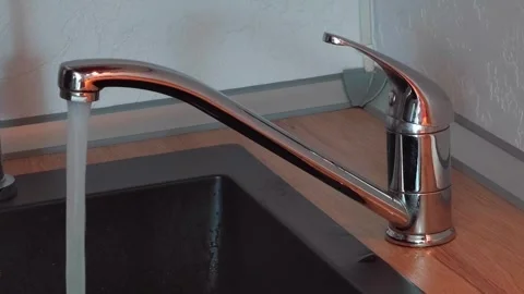 Close-up of a man's hand opening and closing a faucet in the kitchen with water Video stock 274060307