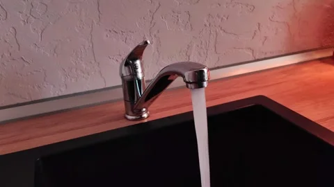 Close-up of a man's hand opening and closing a faucet in the kitchen with water Video stock 274060308