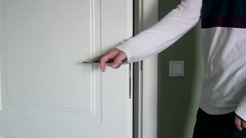 Close-Up of a Man's Hand Opening a White Wooden Door in a Modern Apartment Stock Footage 343929237