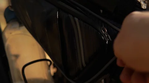 Close-up man's hand opens a bicycle bag and takes out a pump. 库存影片 127347712