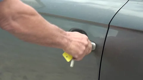 Close-up of man's hand opens with key the grey car door. Slow motion Stock Footage 208295347