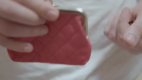 Close up of a man's hand opens a red wallet and pours a few coins into his palm Stock Footage 213968653