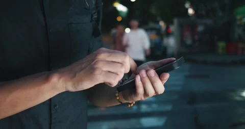 Close-up mans hand operating a smartphone, symbolizing modern age of urban Stock Footage 312505816