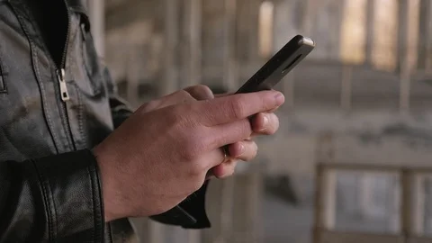 Close-up of a man's hand with a phone against the background of an old building. Stock Footage 127902665