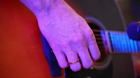 Close-up of a man's hand playing an acoustic guitar during an acoustic concert. Stock Footage 228284548