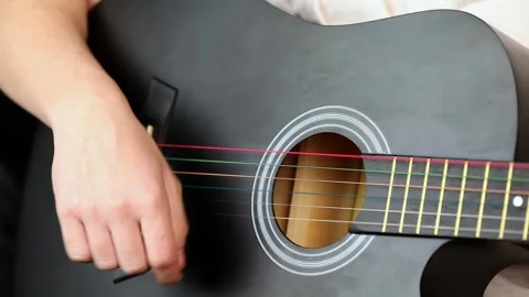 Close up of a man's hand playing a black guitar Stock-Footage 232020812