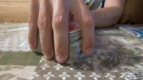 Close up of a man's hand playing with game cards Stock Footage 112740275