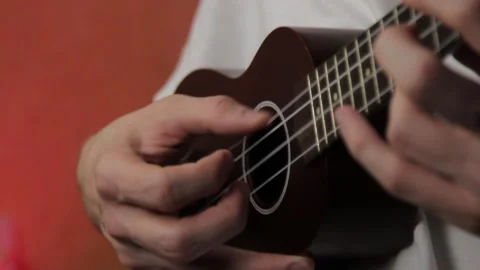 Close-up of mans hand playing ukulele in white t-shirt Stock Footage 148708283
