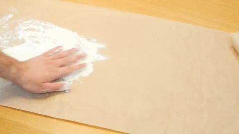 Close-up of a man's hand pouring flour on baking parchment. Home cooking, do it Stock Footage 269834328