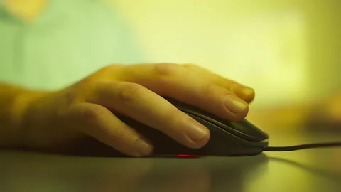Close-up of a man's hand presses the buttons of a computer mouse, evening light Stock Footage 149997309