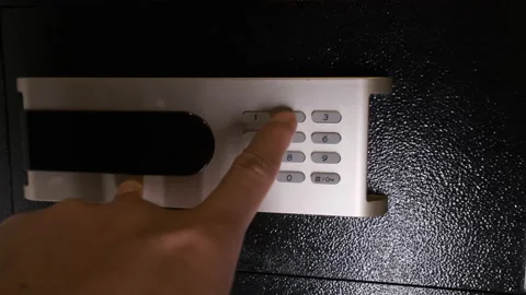 Close-up of a man's hand pressing a button to open a safe hidden in the wardrobe Stock Footage 207683684