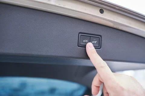Close-up of a man's hand pressing a button on a car door. Photos