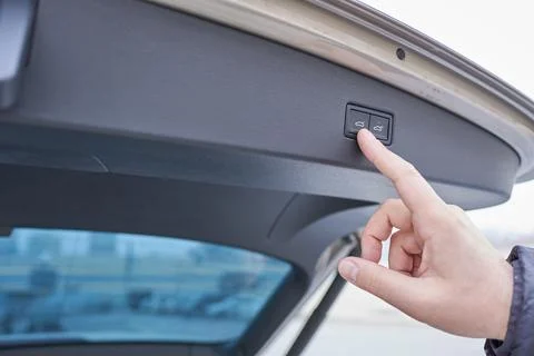 Close-up of a man's hand pressing a button on a car door. Photos