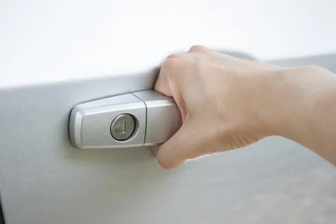 Close up of a man's hand pulling gray car's door handle Stock Photos