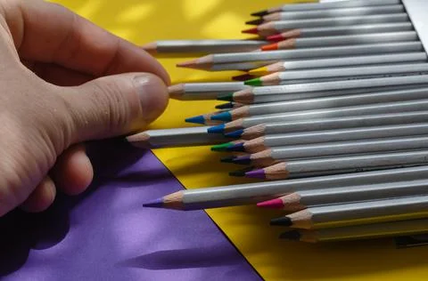 Close-up of a man's hand pulling a gray wooden pencil out of a box. Set of mu Stock Photos
