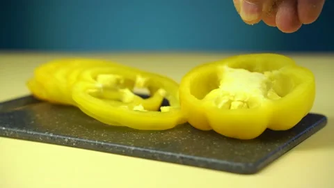 Close up, man's hand puts salt on slices of sweet pepper, Stock Footage 135836757