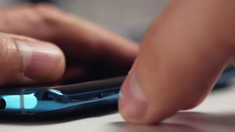 Close-up of a man's hand removing a tray with two nano-SIM cards from a modern Stock Footage 156510624