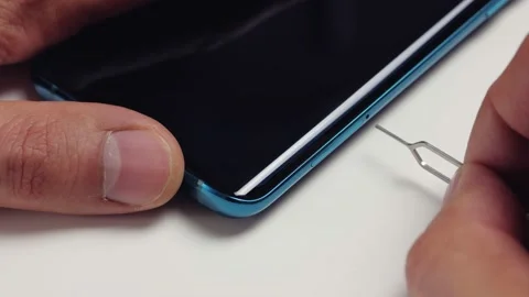 Close-up of a man's hand removing a tray with two nano-SIM cards from a modern Stock Footage 156547018