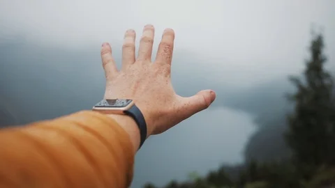 Close up of a man's hand rises in the mountains on the background of the lake Stock Footage 94533988