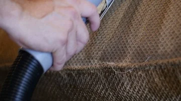 Close up of mans hand running a wet vacuum down a couch cushion in slow motion Stock Footage 85868071