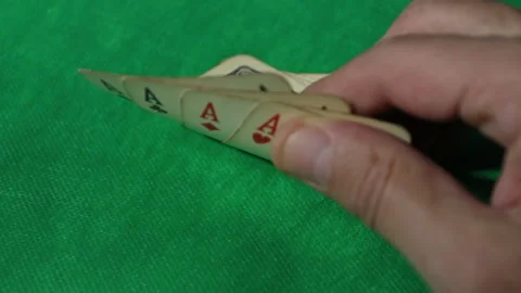 Close up, a man's hand scans his four aces while playing poker. Stock Footage 140208373