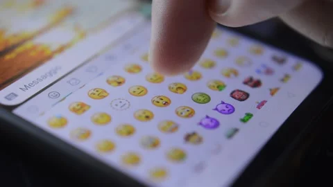 Close-up man's hand scrolling yellow emoji icon on his phone. phone emoticon 스톡 동영상 204843732