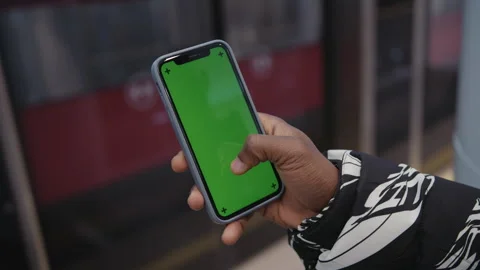 Close-up of a man's hand that scrolls across the phone,subway platform.Chromakey Stock Footage 279732760