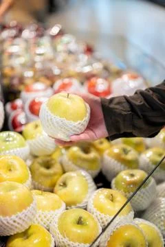 A close-up of a man's hand selecting fruit from a fruit cart while grocery .. Foto stock