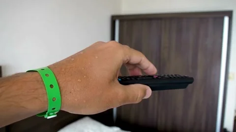 Close up of man's hand selects tv channels with remote control at home. Stock Footage 257873811