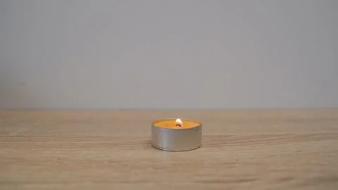 A close-up of a man's hand setting fire to an orange scented candle with a Stock Footage 203212215