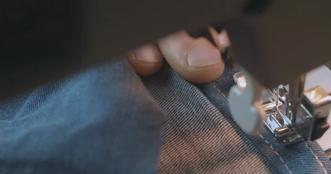 Close-Up Man's Hand Sewing With Denim Jeans On A Sewing Machine. Cinema 4k Stock Footage 121535901