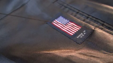 Close-up of a man's hand sewing a label onto a suit jacket Stock Footage 311924540