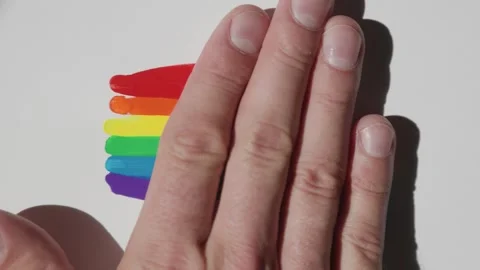 Close-up of a man's hand smearing drops of acrylic paints. LGBT design, rainbow Vídeo Stock 246460465