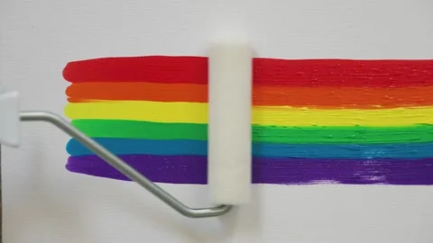 Close-up of a man's hand smearing drops of acrylic paints. LGBT design, rainbow Stock Footage 246460539