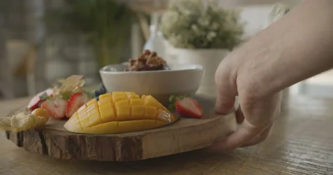 Close-up of man's hand spinning plate with smoothie and fruit mix on the table Stock Footage 103798376