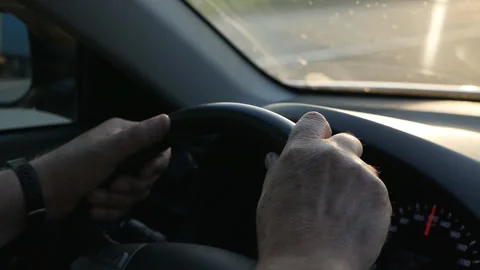 Close-up of a man's hand on the steering wheel while driving a car. Man driving Vídeo Stock 138167808