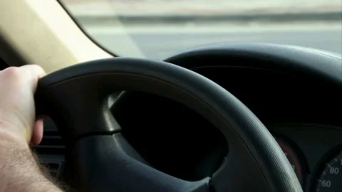 Close up from a man's hand on a steering wheel in a sunny day, driving a car. Stock-Footage 336266096