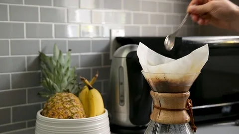 Close-up of a man's hand stirring coffee in a drip coffee flask with a fruit Stock Footage 115329050