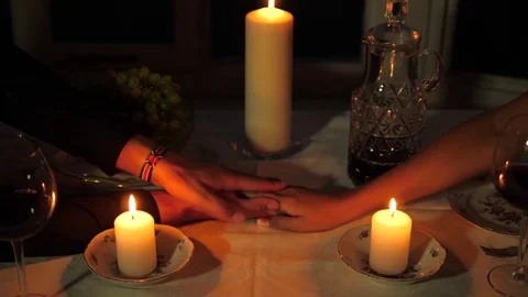 Close up Of Man's Hand Takes The Woman's Hand Over The Table Candles Stockbeeldmateriaal 82827167