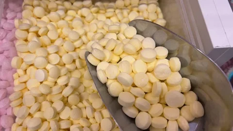 Close-up of mans hand taking colourful candies with scoop. Box with many Stock Footage 312012674
