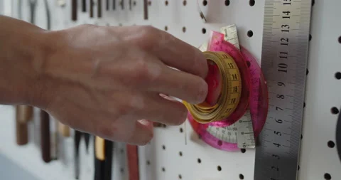 Close-up of a man's hand taking measuring tape off a hook. Stock Footage 146131085