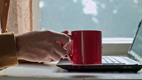Close-up of a man's hand taking a red mug with a hot drink. slow motion. Stock Footage 186898415